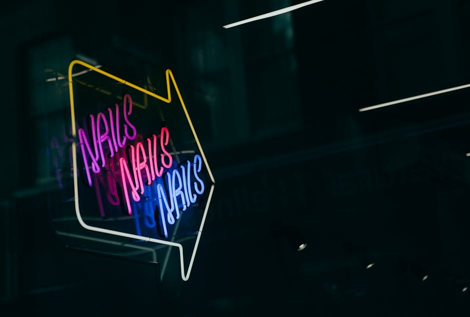 Vibrant neon sign with arrow directing to a nail salon. Perfect for urban and business themes.