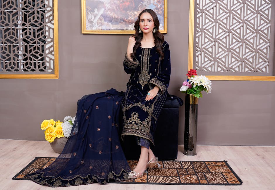 Elegant Pakistani woman in a navy embroidered dress, showcasing traditional fashion indoors.