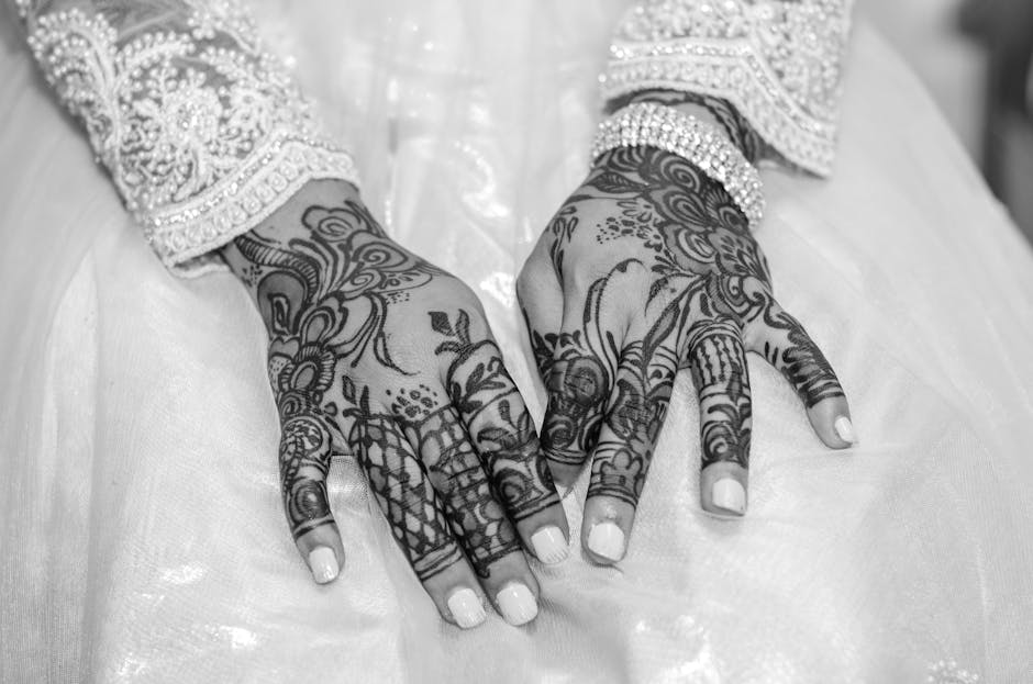 Captivating black and white image of a bride's hands adorned with intricate mehndi designs.