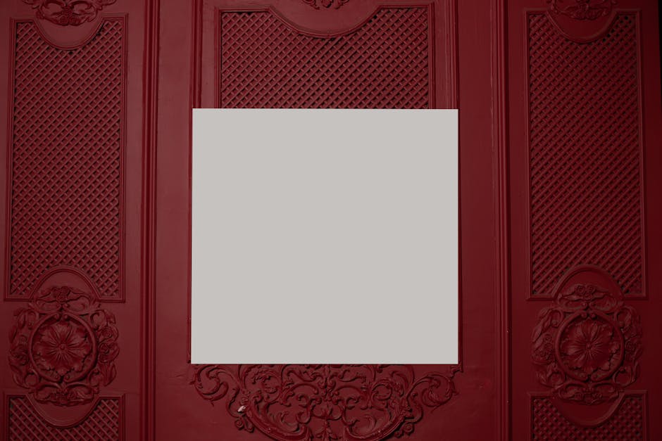 White square board placed on red wall with ornamental elements in bright room