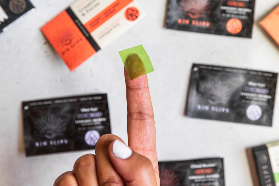 Close-up image of a finger with a translucent bandage surrounded by various product packages.